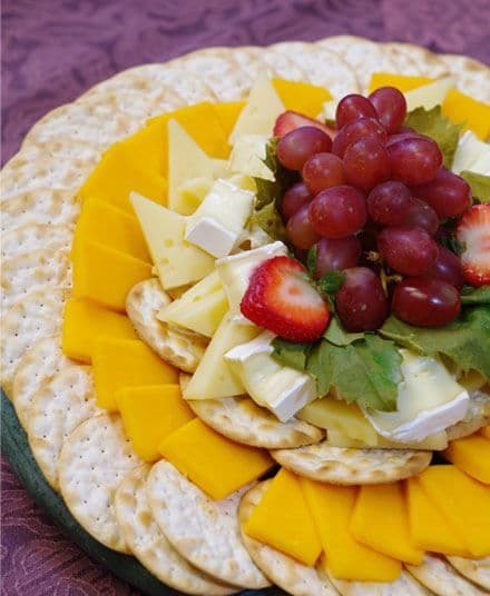 Cheese and fruit platter with grapes, strawberries and crackers