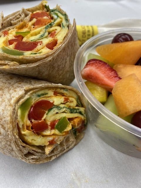 Healthy omelet breakfast wrap with fruit salad, boxed and labeled